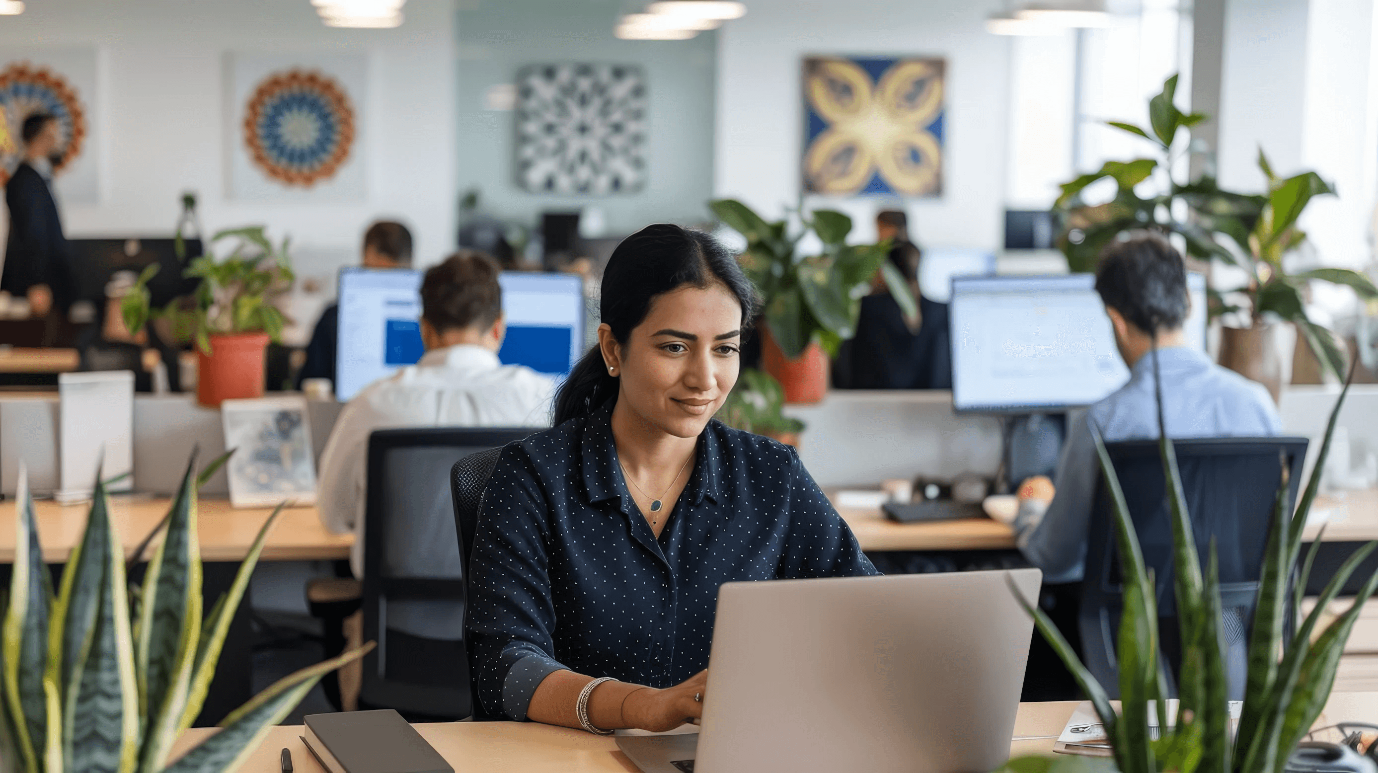 An Oriom team member working at her laptop in the office
